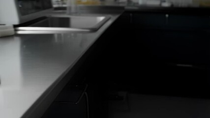 Aufkleber - Various laboratory glassware containing colorful liquids sits on a stainless steel countertop, gradually revealing more of the lab environment as the viewpoint moves further away