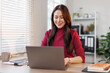 © David - Young Asian girl or Asian businesswoman working at home office with a laptop