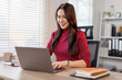 © David - Young Asian girl or Asian businesswoman working at home office with a laptop