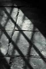 Poster - Captivating monochrome image of light and shadow creating geometric patterns on a textured brick surface