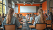 © fangphotolia - Focused Learning: Students' backs fill the frame, engrossed in a class, suggesting an environment of learning. Desks neatly arranged, leading to a screen, all is set for education, with light and air.