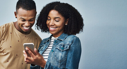 Poster - Happy couple, laughing or social media with phone in studio for conversation or online network on a blue background. Man, woman or smile with mobile smartphone for app, post or connection on space