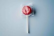 © MrHamster - A single red lollipop sealed inside a clear plastic wrapper