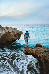 Wall Mural - man traveling in greece solo backpacker walking on the beach active vacations hiking outdoor, touris