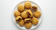© hattaarshavin - A plate of ma’amoul cookies filled with dates and nuts on a white background