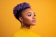 © Leo Rohmann - Stylish young woman with purple curly hair wearing yellow sweater against vibrant yellow background confident modern fashion portrait