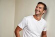 © KumCup - Smiling Man in a White T-Shirt Against a Neutral Background Radiating Happiness and Confidence