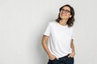 © KumCup - Cheerful Young Woman in Casual White T-Shirt and Glasses Smiling Against Plain Background