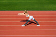 © Yevhen - Sports exercises and stretching in the stadium. Physical training girl. Fit girl do outward lunging. Girl athlete do sport workout. Trainer or coach training. Female runner stretching before workout