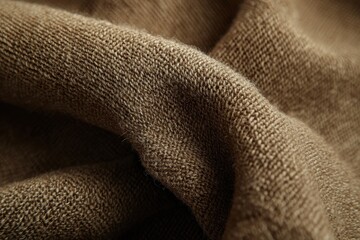 Poster - Detailed close-up of a folded brown knitted fabric, showcasing the intricate texture and pattern of the weave, offering a warm and cozy aesthetic.