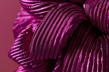 Poster - Close-up capturing the vibrant texture of a shiny, pleated purple fabric with dynamic folds, creating a rich, luxurious, and abstract pattern.
