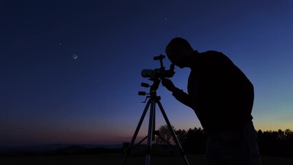 Wall Mural - amateur astronomer looking at the evening skies, observing planets, stars, moon and other celestial 