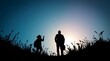 © Dinil - Silhouette Photograph of Two Figures Walking on Grassy Hill at Sunset, Backlit with Vibrant Sky and Wildflowers