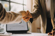 © ARMMY PICCA - Businesswoman shaking hands with businessman at desk in office