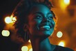 © Atlas Studio - Joyful woman smiles brightly against a backdrop of warm glowing lights during a nighttime celebration