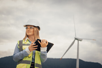 Poster - A dedicated female engineer is passionately working on a wind farm project, using advanced machinery in a sustainable landscape and efficiently monitoring the turbines with her tablet