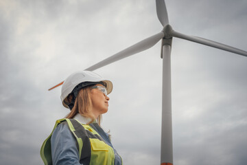 Poster - A skilled female engineer is overseeing the installation of wind turbines at a renewable energy site, highlighting the importance of sustainability and teamwork in modern engineering practices