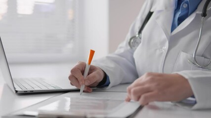 Poster - A medical professional is diligently writing notes on their laptop, meticulously documenting important details regarding patient care, treatment plans, and diagnoses within the healthcare workflow