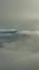 Wall Mural - moving down between the clouds. aerial view of clouds and mountains at sunrise. traveling by air bac