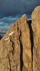 Wall Mural - aerial around view of amazing rocky mountains in snow at sunset, dolomites, italy. vertical video