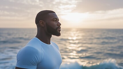 Poster - Standing proudly by the ocean, a man gazes out at the horizon as the sun descends, casting warm tones across the water. This tranquil moment captures deep contemplation and connection with nature