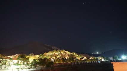 Poster - Landscape of a night sky illuminated by shooting stars over a mountain landscape