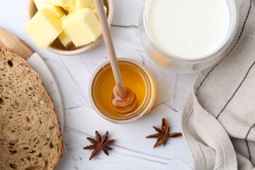 Wall Mural - Sweet honey, butter, bread and milk on white table, flat lay