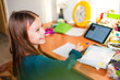 © ADDICTIVE STOCK - Schoolgirl Smiling While Doing Homework at a Desk