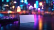 © mlangsen - Blank card next to the keyboard in an office with city lights at nighttime