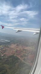 a bird view from airplane window seat showing landscapes of cities and forrest