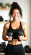 © MikeLegend - Smiling woman lifting dumbbells in home gym setting