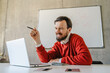 © ADDICTIVE STOCK - Man smiling while working on laptop in a casual office