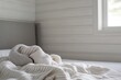 © malayeka - Cozy cream knit blanket on a bed.
