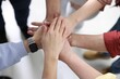 © New Africa - Unity concept. People holding hands together indoors, above view