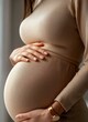 © Yarttari - Pregnant Woman Gently Holding Baby Bump in Beige Dress