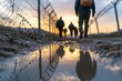 © MMerellinn - Unlawful passage: refugee attempts illegal crossing, migration struggles, border security, barbed wire obstacles, human rights issues, displacement crisis, global challenges, undocumented movement.