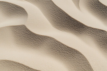 Poster - Wavy sand dunes create mesmerizing pattern with light and shadow play