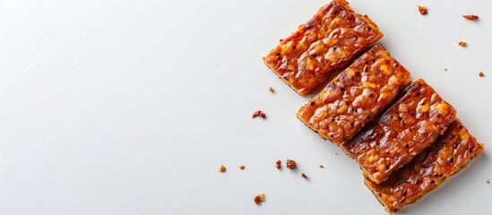 Aufkleber - Tempeh slices arranged diagonally on a white background with ample copy space on the left side for text or additional content.
