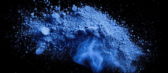 Poster - Vibrant blue powder texture scattered against a black background creating a modern aesthetic ideal for graphic design and creative applications.