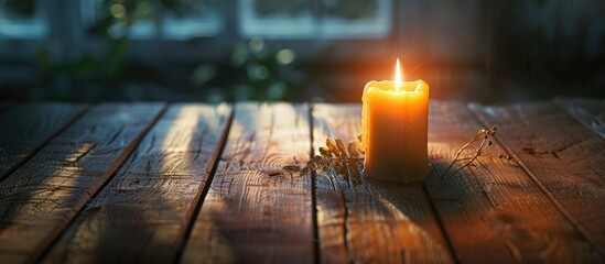 Aufkleber - Candle casting warm golden light in a dimly lit room with wooden table and soft shadows creating inviting copy space on the right side