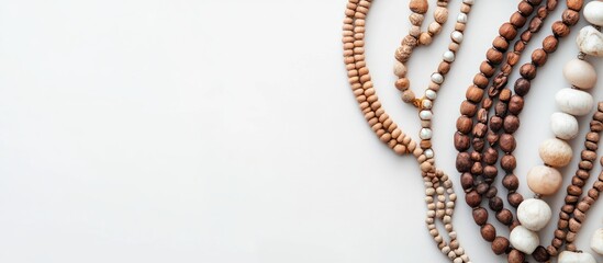 Poster - Natural material necklaces in shades of brown and cream arranged artistically on a white background with varying textures and sizes for visual interest.