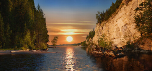 Wall Mural - a magnificent sunset over rugged cliffs and a calm river, under a vibrant sky.