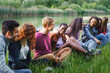© Lomb - Diverse group of friends laughing together by the lake in nature
