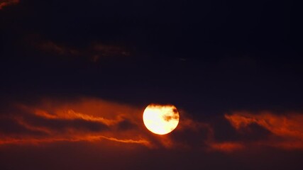 Wall Mural - the big sun is shining through a dark stormy sky. an impressive cloudscape of thunderclouds as abstr