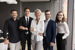 © fizkes - Happy business is successful team. Portrait motivated ambitious smiling friendly young people managers corporate workforce lead by senior female ceo director trainer stand in group at office workplace