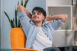 © carballo - young man or student sitting indoor with laptop and relaxed expression or gesture