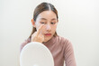 © KMPZZZ - Ophthalmology care, eyesight or vision. Asian young woman, girl hand holding and putting, wearing soft, daily disposable contact lens on her face with finger, looking into eye. Medical and health care