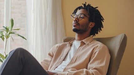 Poster - A man wearing glasses and a brown shirt is sitting in a chair