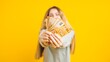 © DMegias - Young woman showing euro banknotes on yellow background