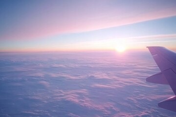 Aufkleber - Morning light bathes fluffy clouds in gentle pink and blue tones as the sun rises, creating a tranquil atmosphere captured from above an airplane wing
